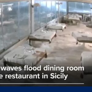 Powerful waves flood dining room of seaside restaurant in Sicily