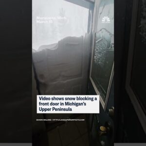 Snow piles up against door after Michigan blizzard