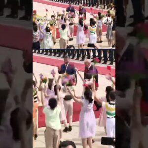 Children outside of the Great Hall of the People in Beijing greet President Trump