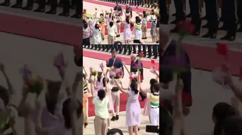 Children outside of the Great Hall of the People in Beijing greet President Trump